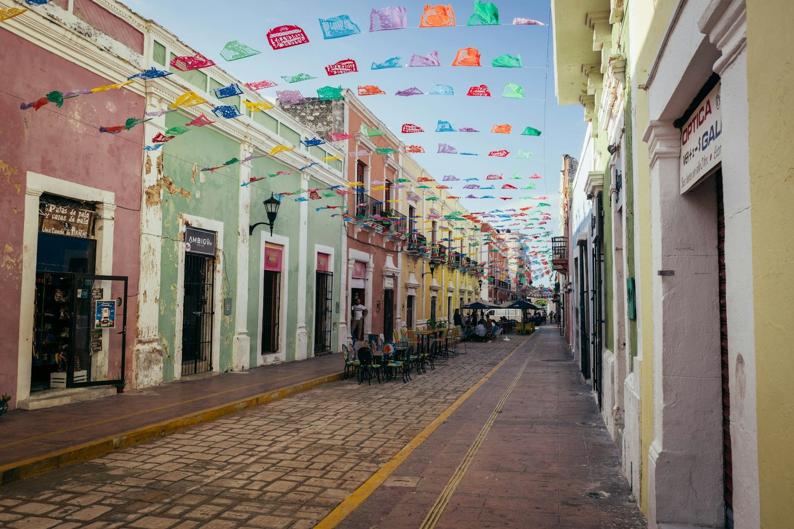 Calle colonial con fachadas de colores y papel picado